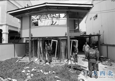 15日，泰国曼谷，一名警官正在检查在爆炸中受损的房屋。图/人民图片