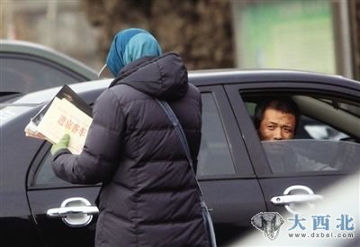 9日下午，白鹿收费站外，一名女子在向一外地车主销售进京客车证。本报记者 王贵彬 摄