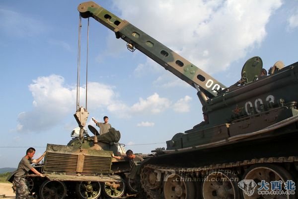 沈阳军区某摩步旅官兵正在利用大型装备抢修坦克。
