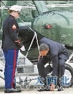 美国总统奥巴马当地时间3月30日在乘坐专机出行前为—名海军陆战队女中土弯腰捡起—枚硬币。