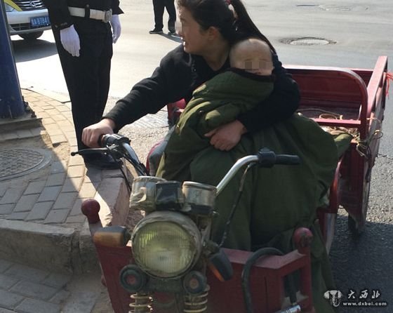 女子单手抱幼儿驾三轮车 后载两幼童和狗